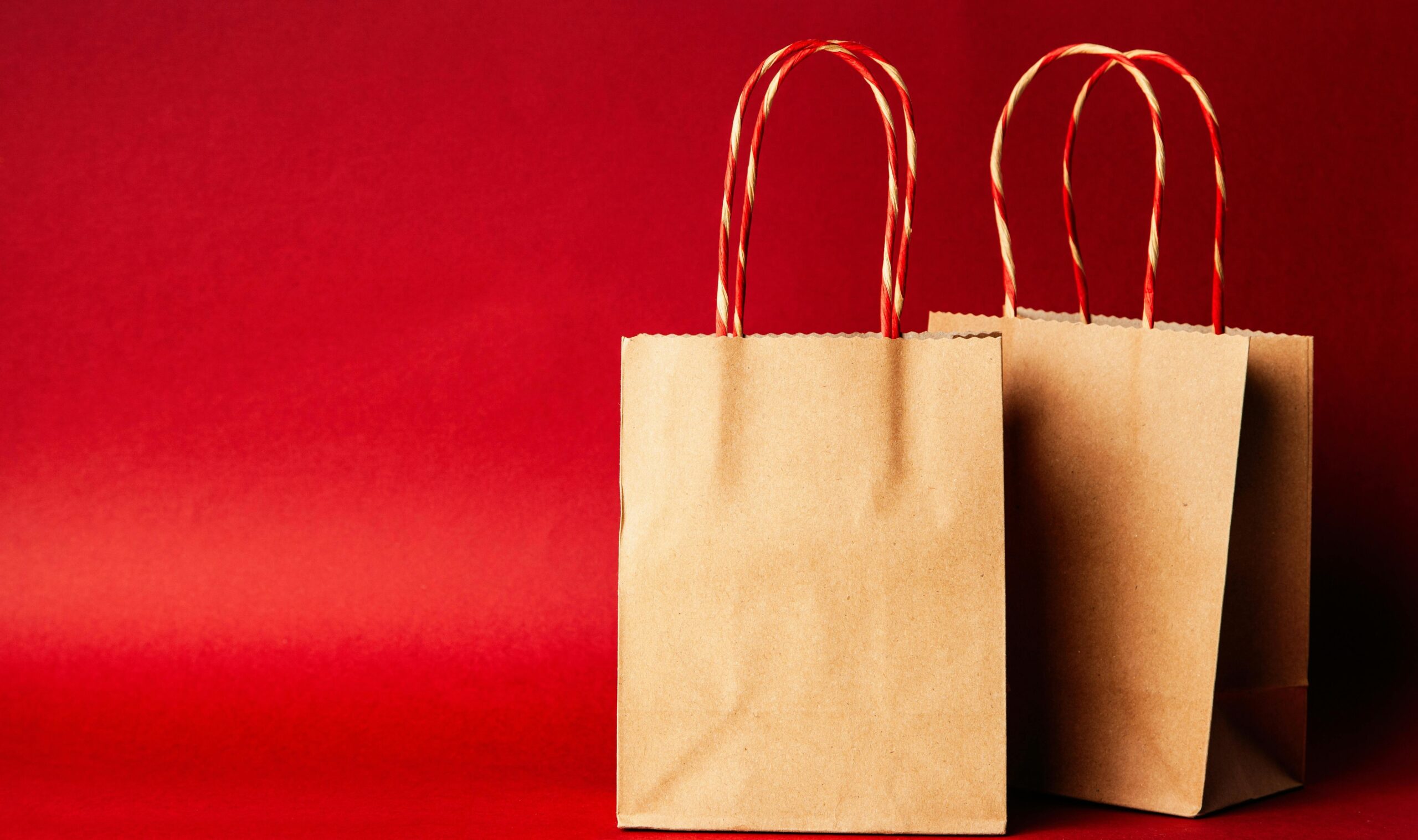 A close-up image of a brown paper bag filled with organic cat food surrounded by green leaves